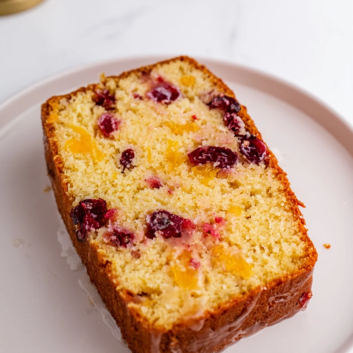 Golden-brown Seasonal Cranberry and Orange Bread, steaming, with a slice showing juicy cranberries.