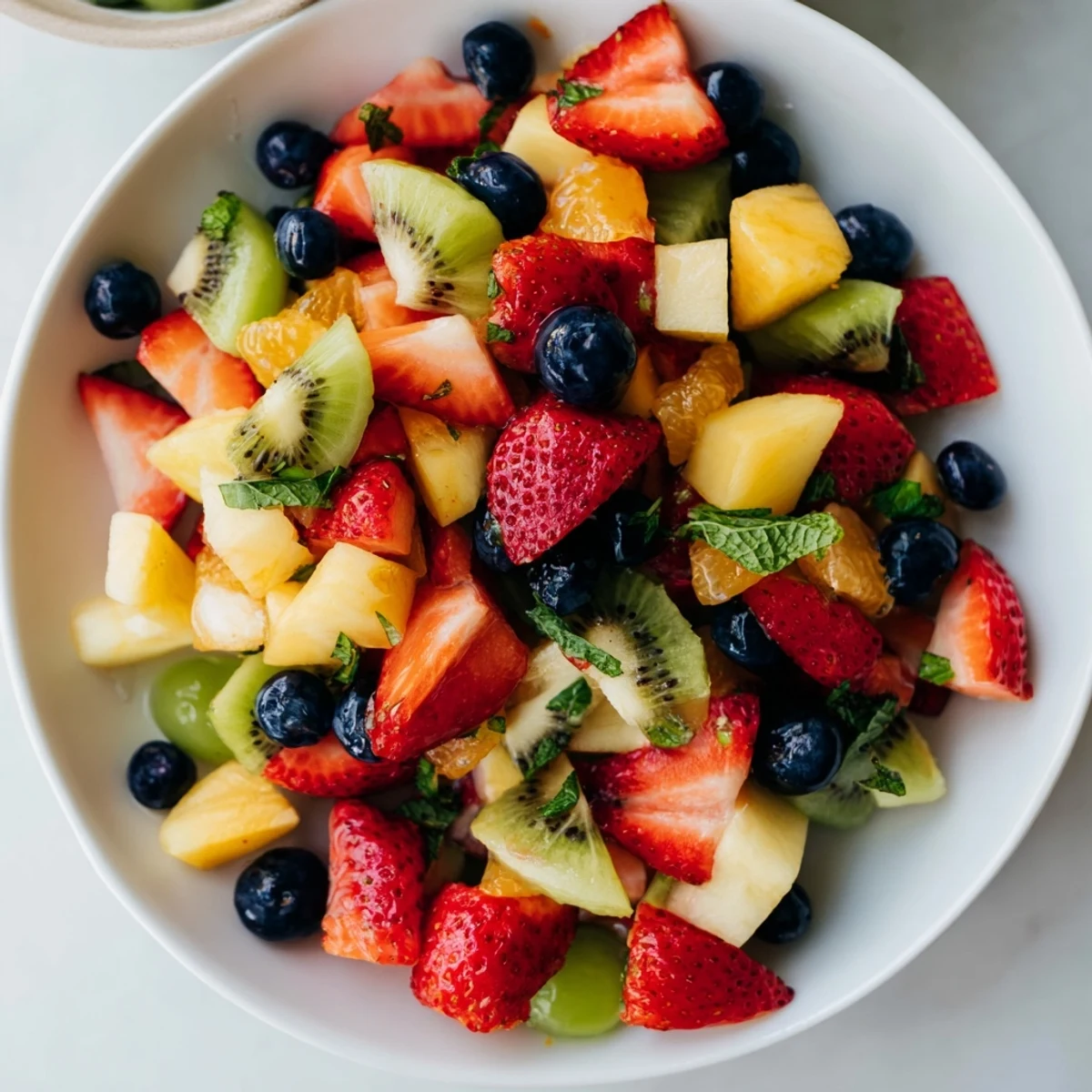 Vibrant fruit salad with honey-lime dressing, overflowing with colorful fresh berries and citrus segments.