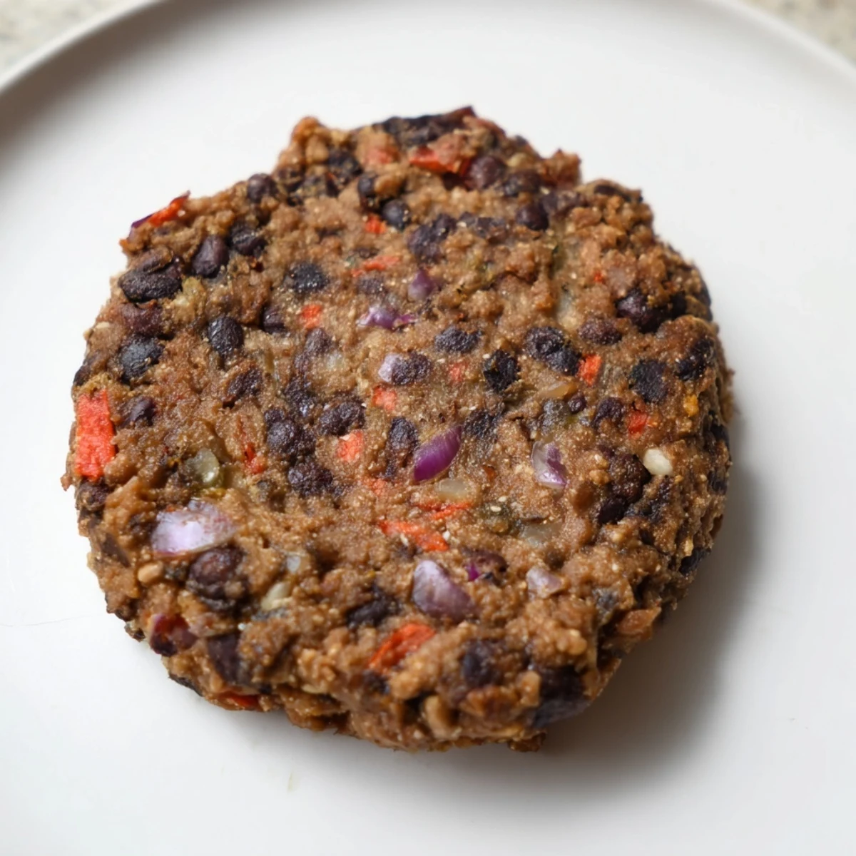 A close-up of a perfectly cooked Vegetarian Black Bean Burger, showcasing its delicious texture.