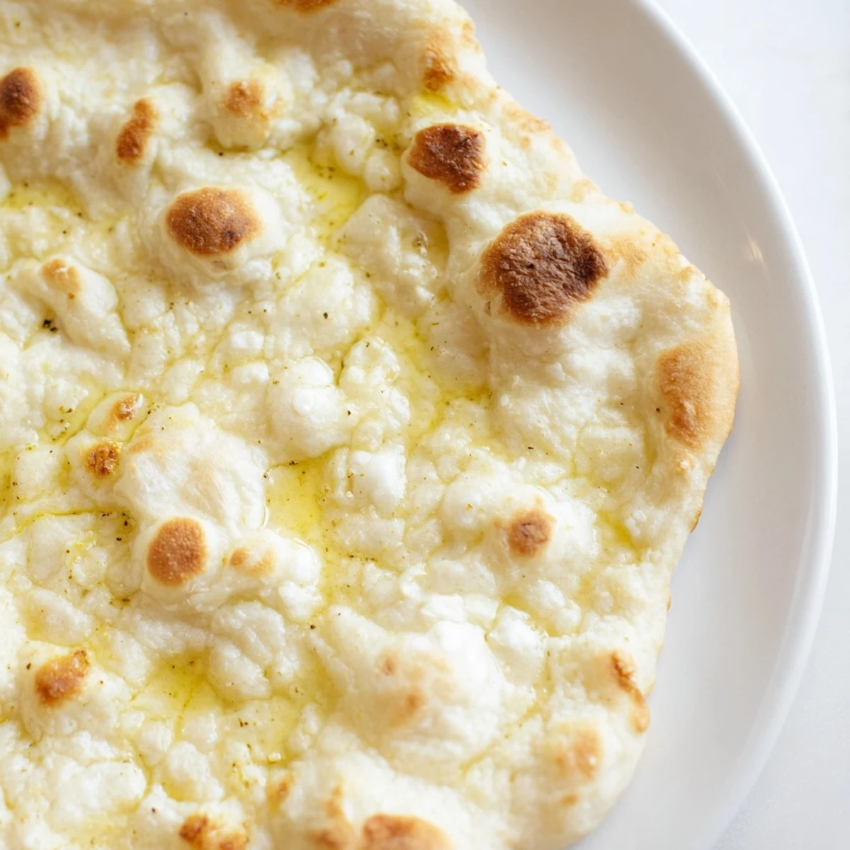 Freshly cooked three-ingredient easy flatbreads ready to enjoy, with puffed-up spots and a soft inside.