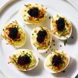 Creamy deviled eggs, adorned with luxurious caviar and crispy shallots; a delightful party dish.