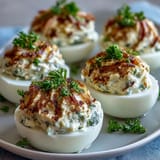 Adorable deviled egg chicks with carrot beaks and peppercorn eyes, perfect for Easter snacking.