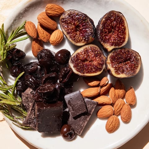 A beautifully balanced Winter Solstice Board showing savory olives, figs, and decadent dark chocolate alongside Brie cheese.