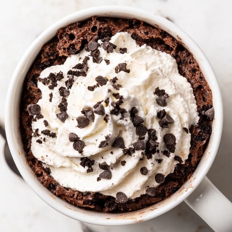 Warm Oreo mug cake with melting chocolate, perfect for a quick, chocolatey treat.
