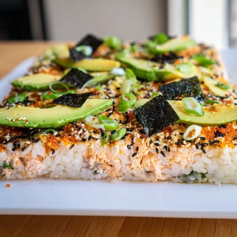 Warm Sushi Bake Casserole, showcasing creamy avocado slices, nori, and sesame seeds; ready to be served.