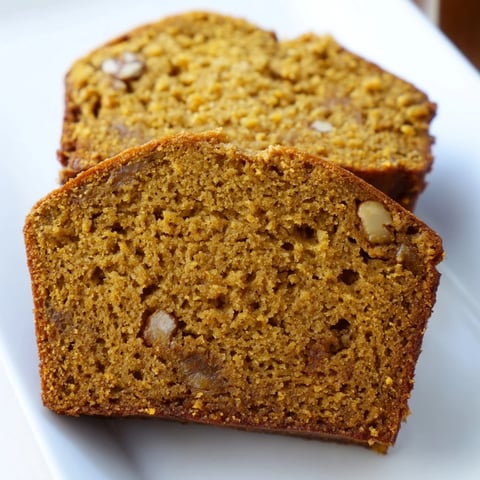Freshly baked pumpkin bread loaf, warm from the oven, showcasing a moist, spiced crumb and golden-brown crust.