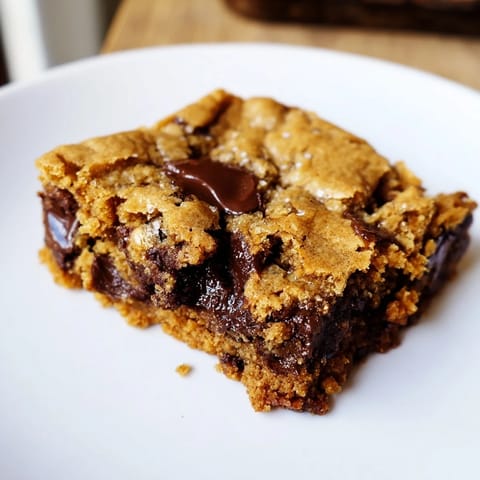 Warm, freshly baked Ultimate Gooey Chocolate Chip Cookie Bars with a center that’s soft and irresistible.
