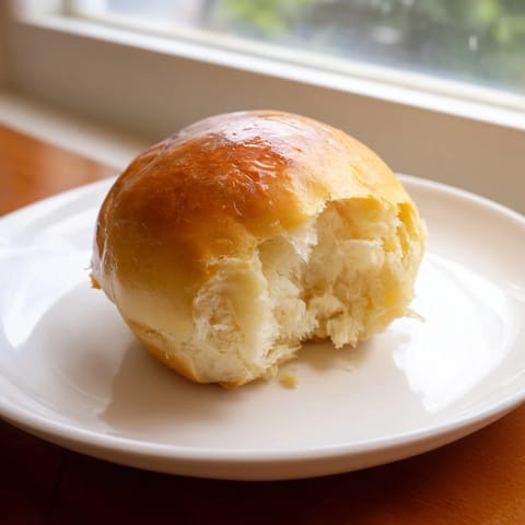 Warm, soft Homemade Golden Dinner Rolls, perfect alongside a comforting, savory holiday meal.