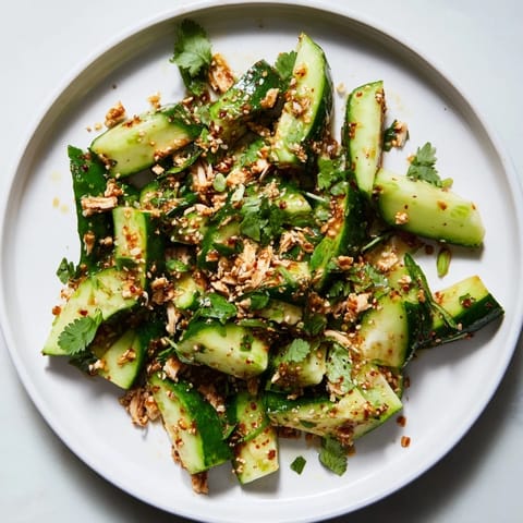 Close-up of the flavorful Whole Cucumber Logan Salad, featuring refreshing cucumbers and shredded chicken.