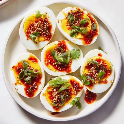 Bright, flavorful Chili Oil Eggs are adorned with green onions and sesame seeds, ready to eat!