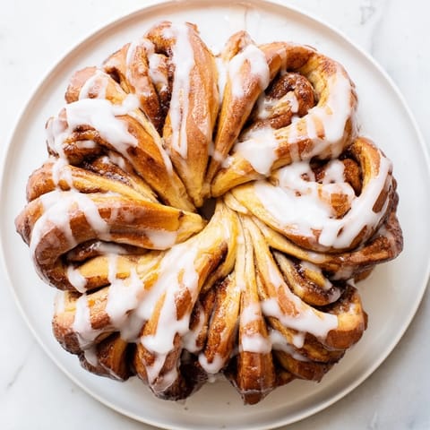 Golden-baked Cinnamon Roll Pull-Apart Snowflake with swirling cinnamon, ready to serve warm with sweet vanilla icing.