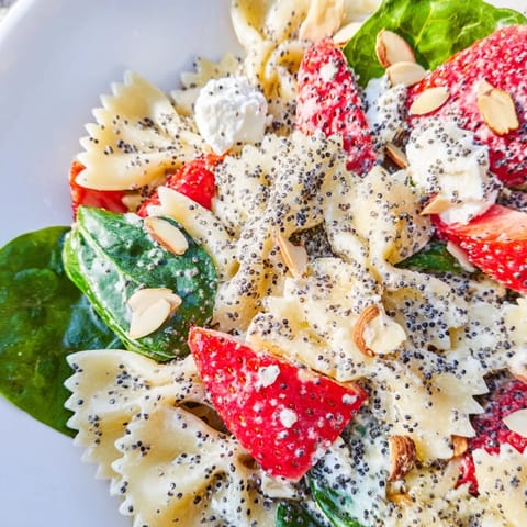 Fork-ready Spring Spinach Strawberry Pasta Salad featuring tender farfalle, juicy strawberries, fresh basil, and tangy poppy seed dressing, finished with crumbled feta and sliced almonds.  