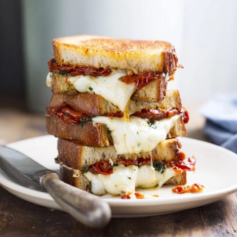 Slow-roasted tomato slices and herb pesto melt into gooey cheese inside crispy grilled bread.