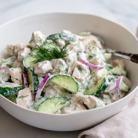 Creamy Cucumber Chicken Salad served chilled in lettuce cups with a dollop of Greek yogurt dressing and green onions.
