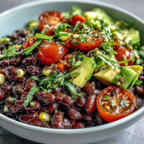 Hearty plant-based taco bowl with seasoned black beans and colorful fresh vegetable toppings.
