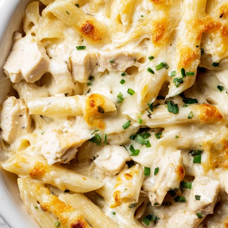 Tender shredded chicken and penne pasta coated in creamy ranch sauce, ready to serve for dinner.
