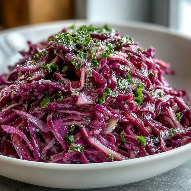 Freshly prepared Red Cabbage Coleslaw With Apple and Parmesan garnished with shaved cheese and sliced green onions.