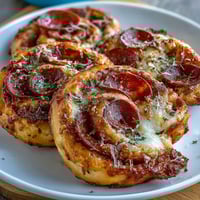 Baked pizza pinwheels with pepperoni and mozzarella in flaky golden pastry spirals, perfect for parties and snacking.