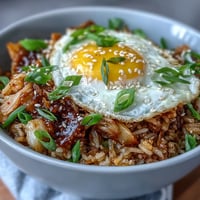 Vibrant Kimchi Cabbage Fried Rice topped with a perfectly runny fried egg.